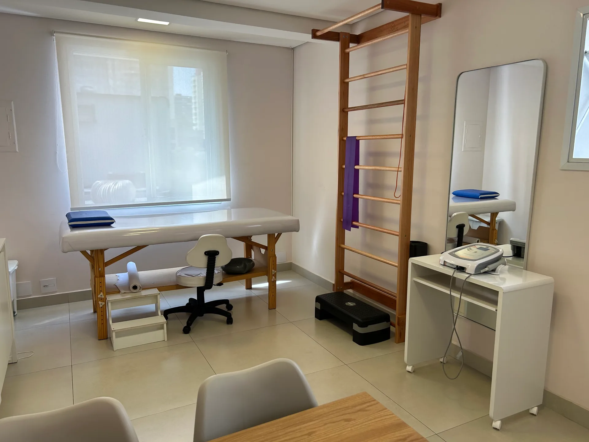 Sala de fisioterapia da Vyta em Pinheiros, com maca de atendimento, espaldar e espelho de corpo inteiro